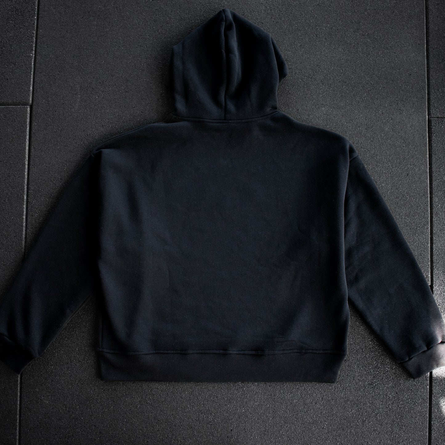Black hoodie on a dark textured surface