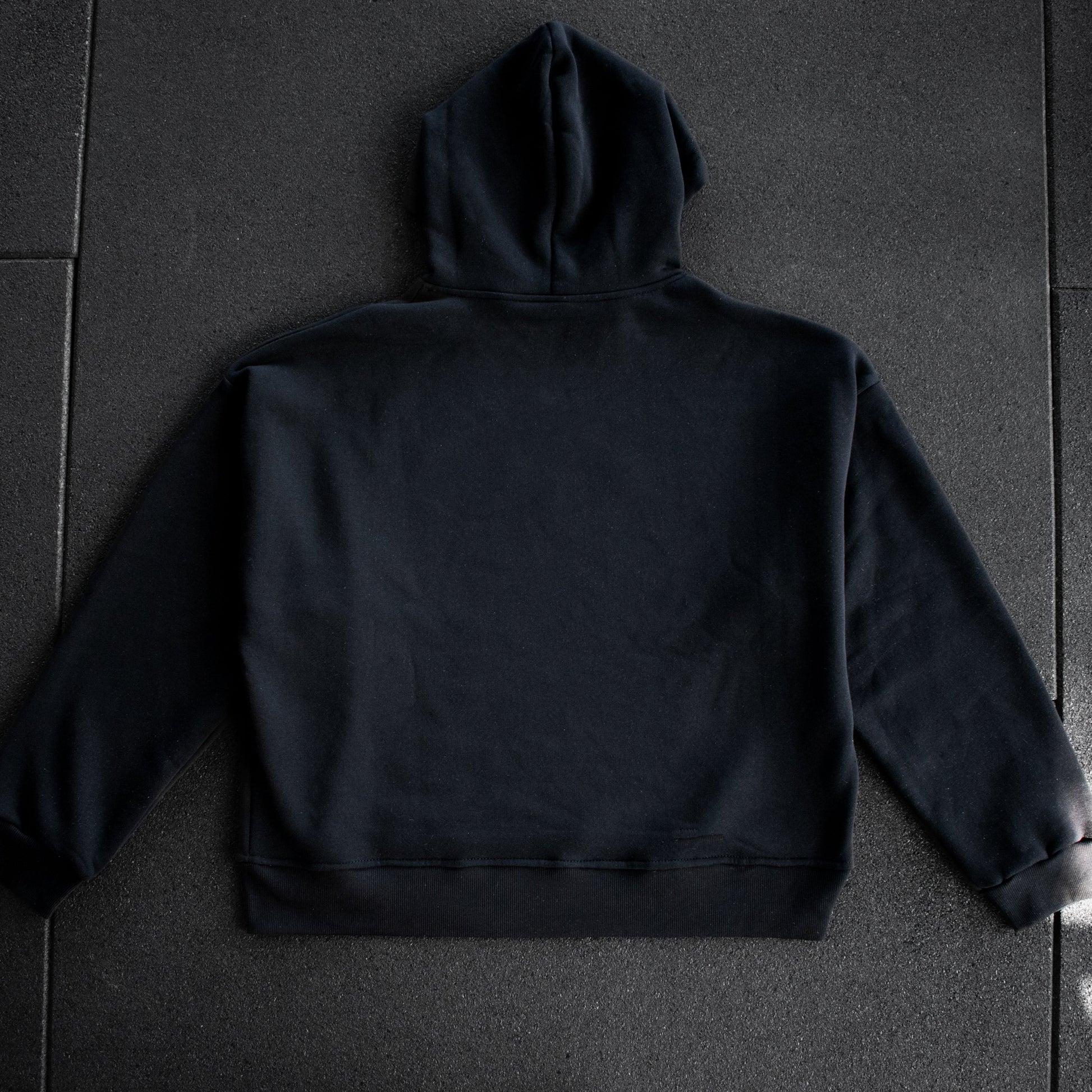 Black hoodie on a dark textured surface