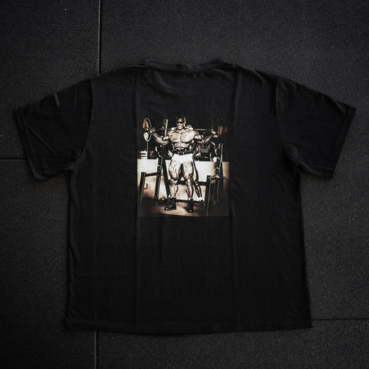 Black t-shirt with a graphic of a person lifting weights on a dark surface