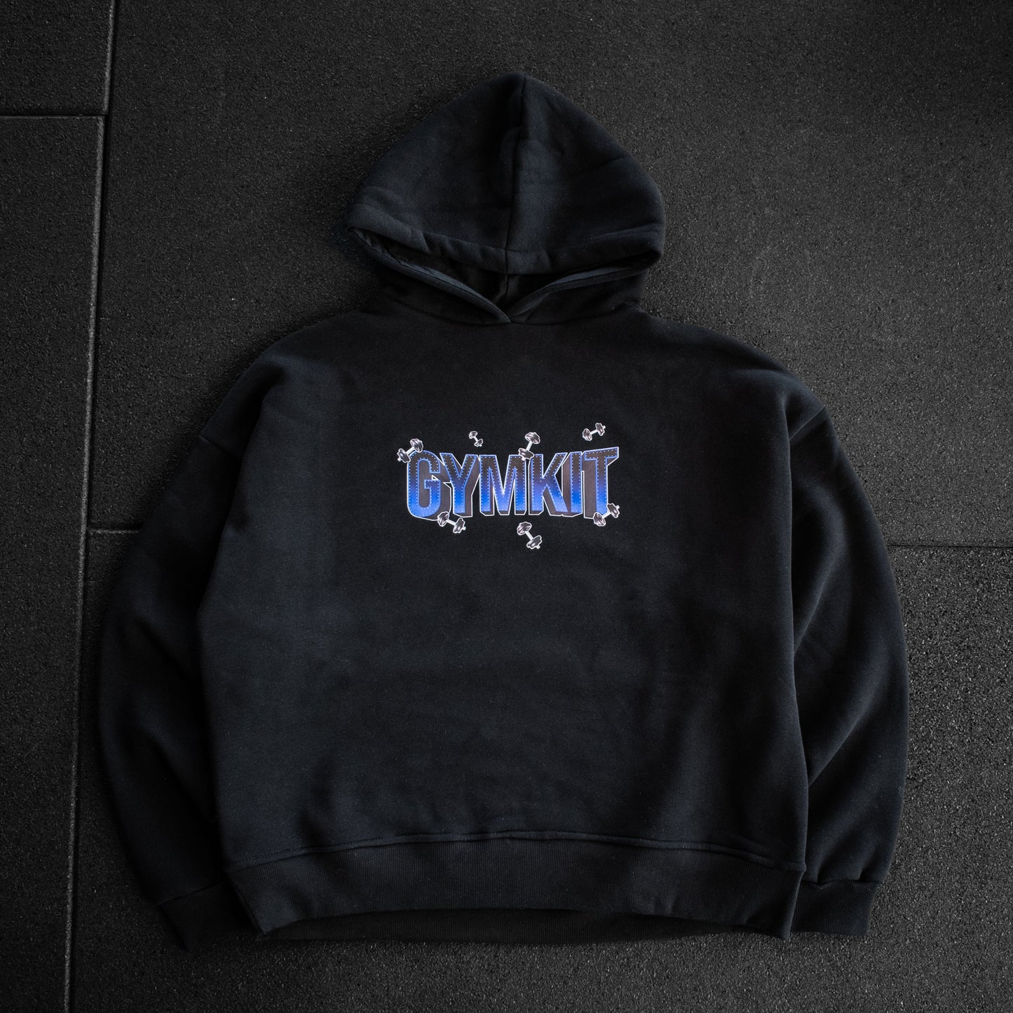 Black hoodie with 'GYMKIT' logo on a dark tiled floor