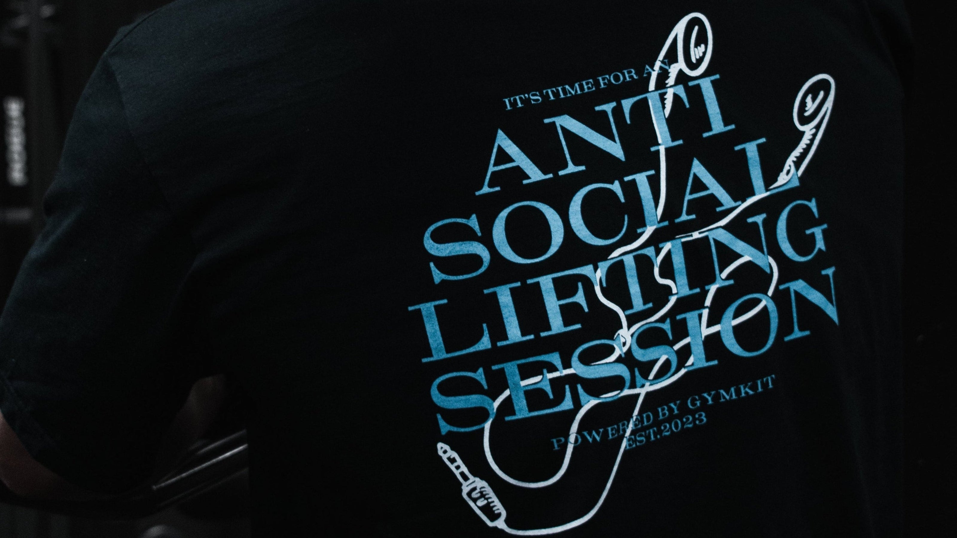 Person wearing a black t-shirt with a humorous message about lifting weights.